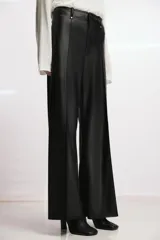 Pantalón de tiro alto efecto piel en color marrón, con pierna ancha y costuras marcadas en la parte delantera. Presenta trabillas en la cintura y cierre frontal con cremallera, botón y gancho metálico.