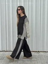 Conjunto de dos piezas en tejido de punto color beige, compuesto por un sweater de calce relajado con mangas a rayas y un pantalón de tiro alto con caída suelta y detalle lateral a rayas.