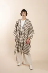 Ruana de lana fina color crudo con terminación envivada.