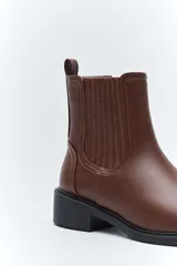 Botas tipo chelsea de caña baja, con laterales elastizados, tirador trasero y suela robusta.