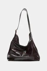 Bolso maxi shopper color marrón oscuro de cuero sintético con asa ancha ajustable con hebilla dorada. Tiene bolsillo interno con cierre y cierre imantado.