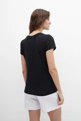 Remera blanca de algodón con cuello redondo y strass plateados formando pequeños dibujos.