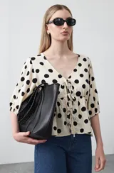 Cartera tipo tote de diseño amplio y textura símil cuero, con asas trenzadas y terminaciones artesanales.