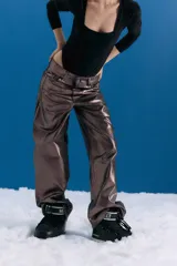 Pantalón de jean estilo oversize de tiro medio-bajo, confeccionado en denim 100% algodón. Presenta un acabado metalizado en tono peltre con efecto lavado violeta, logrando un brillo irregular y profundo. Incluye avíos metálicos personalizados y badana de PU en la parte posterior.