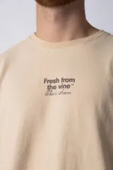 Remera de corte oversize color negro, con cuello redondo y mangas cortas. Presenta una estampa pequeña en el centro del pecho con la frase 'Fresh from the vine' en tipografía blanca.