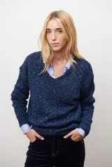 Buzo de punto color azul con motas blancas, escote en V y mangas largas.