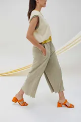 Pantalón capri color beige, de tejido acanalado, con cintura elástica y bolsillos laterales.