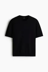 Remera de punto suave color negro, de corte slim fit, con cuello redondo acanalado y mangas cortas.