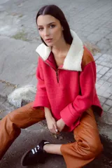 Buzo marrón de lana con mangas rectas, largo medio y cuello con cierre. Aplique de corderito azul en el cuello. Buzo amplio con diseño a cuadros en la parte superior.