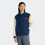 Campera New Balance Athletics Varsity azul marino con mangas color crema y detalles amarillos en los hombros. Logo de New Balance bordado en el pecho.
