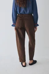 Pantalón de corte barrel en pana color azul marino, con cierre frontal de botones metálicos dorados a la vista y costuras reforzadas en las rodillas.