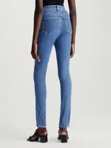 Jeans ajustados de mezclilla elástica, tiro alto, pierna estrecha y lavado azul medio. Presentan diseño de cinco bolsillos y bragueta con cremallera.