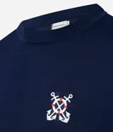 Remera azul marino de viscosa con cuello redondo y mangas cortas. Presenta un bordado con motivos marineros en el frente. Corte regular.