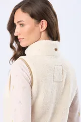 Chaleco de tejido sherpa color crema, con cierre frontal y detalles de terminación en eco cuero color tostado.