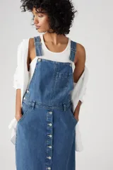 Vestido midi de jean azul con breteles, bolsillo en el pecho y falda recta con botones frontales.
