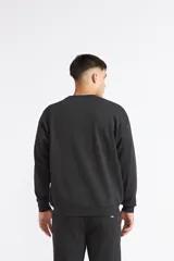 Buzo Quiksilver modelo Mercury Trident de cuello redondo, color negro, de manga larga con puños y dobladillo acanalados, y pequeño estampado en el pecho.