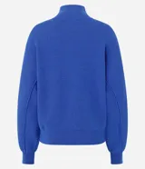 Campera de punto pesado color azul, con cuello alto, cierre frontal con cremallera y bolsillos delanteros con solapa y botones. Cuenta con mangas largas y puños y bajo acanalados.