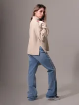Sweater de tejido grueso con cuello alto, corte relajado y mangas largas. Presenta una textura acanalada y un diseño minimalista con etiqueta distintiva de la marca en el ruedo.