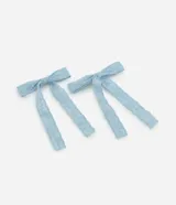 Par de pinzas para el pelo con diseño de lazo, confeccionadas en tela de encaje color celeste con detalles calados.