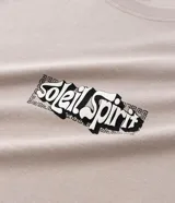 Remera de algodón color beige, corte relaxed (holgado), manga corta y cuello redondo. Presenta un pequeño estampado localizado con lettering estilizado en el pecho.