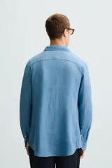Camisa de corte regular fit confeccionada en tejido de lino, con cuello solapa, manga larga con puños abotonados y cierre frontal de botones.