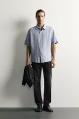 Jeans regular fit confeccionados en denim de algodón celeste con efecto lavado, de cinco bolsillos y cierre frontal con cremallera y botón.