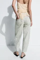 Jeans tiro alto corte tapered de Zara Woman Collection, confeccionados en denim con estampado floral y rayas verticales sutiles. Presenta diseño de cinco bolsillos, trabillas para cinto y cierre frontal con cremallera y botón metálico.