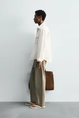 Sobrecamisa de corte regular confeccionada en denim de algodón, con cuello solapa, manga larga con puños abotonados y cierre frontal de botones. Presenta dos bolsillos frontales de plastrón con solapa y bajo con aberturas laterales.