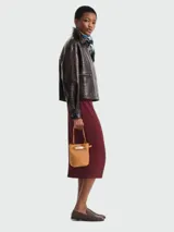 Cartera bucket XS Longchamp modelo Le Smart Flow, color tostado, con diseño estructurado, asa de mano corta y detalle de cierre metálico frontal con tira ajustable.