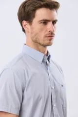 Camisa de manga corta con microcuadros en tonos celestes y blancos, calce slim, cuello con botones y bolsillo frontal con logo bordado.