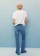 Jeans de tiro medio estilo flare y corte campana, confeccionados en denim de algodón. Presentan diseño de cinco bolsillos, trabillas para cinturón, cierre de cremallera y botón, y terminación de bajo deshilachado.