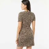 Vestido corto de manga corta con estampado animal print en tonos beige y marrón. Presenta un nudo drapeado en la parte delantera.