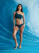 Top de bikini color naranja, estilo bandeau asimétrico con un solo tirante en el hombro y un lazo decorativo en el centro del busto.