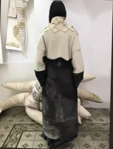 Tapado largo de lana merino afieltrada, color natural combinado con gris, con textura "cubo" en el frente.