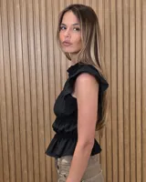Blusa sin mangas de diseño estructurado con múltiples líneas de frunces y elásticos horizontales, cuello alto con volado y diseño ajustado. Presenta estampado de rayas verticales.