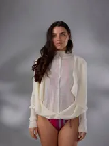 Saco largo de punto color blanco, confeccionado en 100% lana merino natural, con diseño jacquard de ramas, cuello alto, cierre frontal con pequeños botones y aberturas laterales.