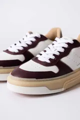 Championes urbanos Urban Haus modelo Mauro, con diseño de paneles en cuero blanco y gamuza verde oliva. Presentan suela de plataforma de goma en tono beige, cierre con cordones blancos y logo de la marca grabado en el lateral.