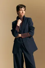Blazer de corte sastrero con solapas clásicas y estructura definida. Presenta un diseño versátil con silueta ligeramente oversized, ideal para un estilo sofisticado y atemporal.