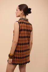 Vestido corto sin mangas con estampado de rombos en azul, rojo y amarillo. Tiene escote con forma de gota y terminación en picos.