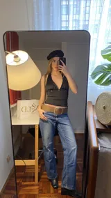 Top negro de estilo halter con espalda descubierta y tiras ajustables para atar. Confeccionado en tejido elástico, presenta un diseño versátil y moderno.