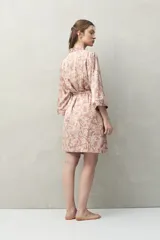 Bata de pijama tipo kimono con estampado animal print en tonos beige y negro, de silueta relajada, con cruce frontal y lazo regulable en la cintura. Tiene mangas amplias y largo por encima de la rodilla.
