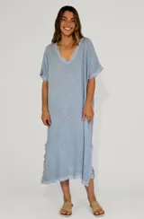 Vestido midi celeste con escote en V y mangas cortas con detalle de flecos en el ruedo.