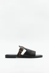 Sandalia baja negra con suela acolchonada y pequeño taco de 2cm. Presenta una capellada de símil cuero texturizado con una tira ajustable con hebilla en estampado animal print.