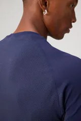 Remera deportiva de alto rendimiento Fabletics, confeccionada en tejido seamless ultraligero y transpirable con paneles de malla laterales para mayor ventilación. Presenta cuello redondo y mangas cortas, diseñada para entrenamientos intensos con propiedades antiolor y de absorción de sudor.