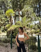 Collar con dije de forma irregular en tonos dorados y plateados, suspendido de un cordón doble de algodón negro.