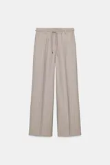 Pantalón de tiro alto con diseño de espiga, pernera recta y bolsillos frontales. Incluye un cinturón trenzado a tono y cierre frontal con cremallera, botón y gancho.