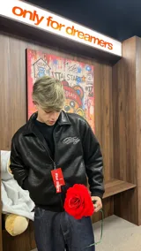 Campera de cuero sintético negro con diseño tipo bomber, cuello camisero y puños y ruedo elásticos. Presenta un bordado grande en la espalda con tipografía cursiva en color blanco.