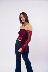 Blusa de encaje color bordó con diseño off-shoulder, mangas largas acampanadas y detalle de lazo frontal ajustable.