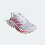 Championes de running Adidas modelo Comfortglide para mujer, con parte superior de malla transpirable en color blanco y gris. Destacan las tres tiras laterales en color fucsia y una entresuela Dreamstrike diseñada para brindar amortiguación y confort. Cuentan con cierre de cordones y detalles reflectantes.