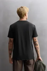 Camiseta de entrenamiento de ajuste regular, color verde oliva, confeccionada en tejido técnico ligero y elástico con estructura. Presenta cuello redondo, manga corta y costuras planas.